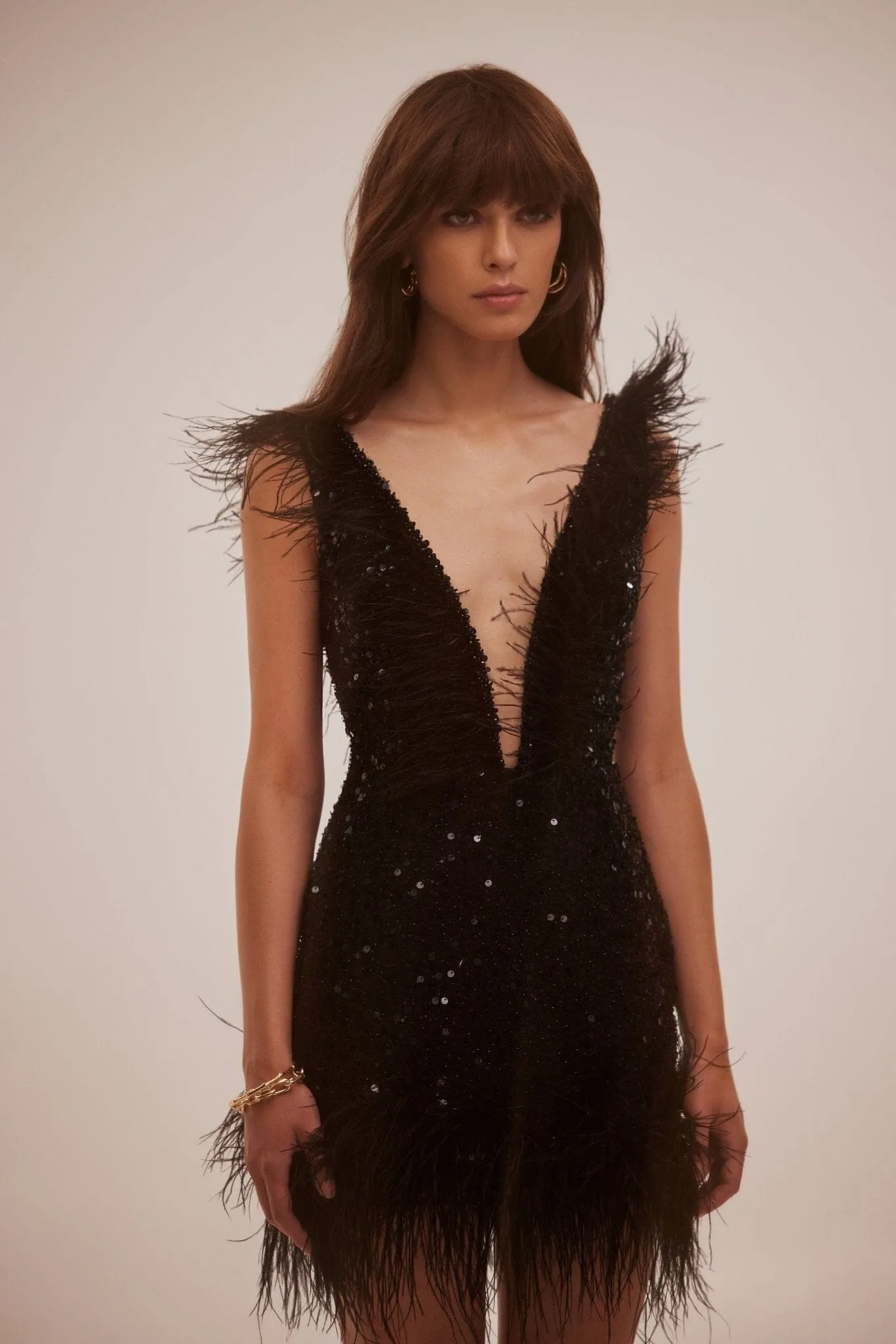 Dramatic cocktail dress on straps decorated with sequins and feathers